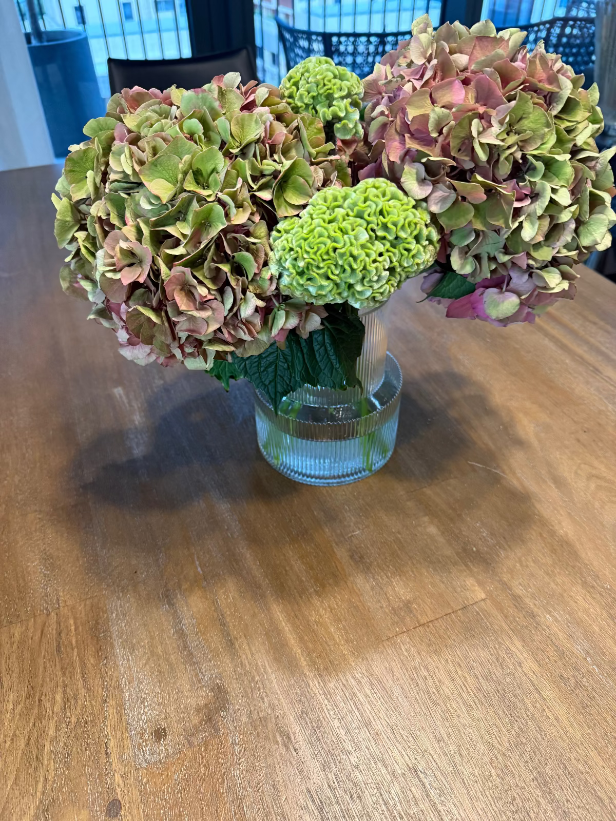 Bouquet of flowers in a clear vase on a wooden table
